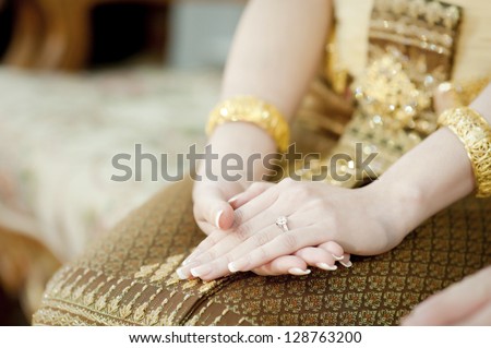 Close up of Thai bride\'s hands with wedding ring on her finger