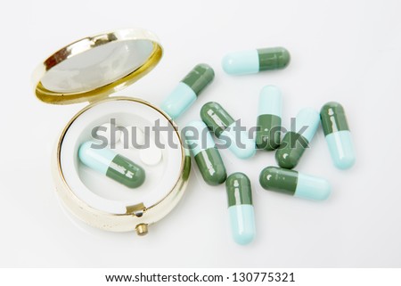Pills and pill box on white background