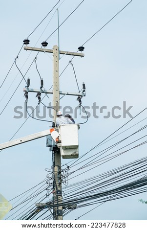 Electrician lineman repairman worker at climbing work on electricity post