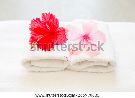 Stacked white spa towels with Hibiscus flower