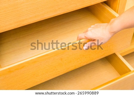 wooden cupboard with hand opened empty drawers