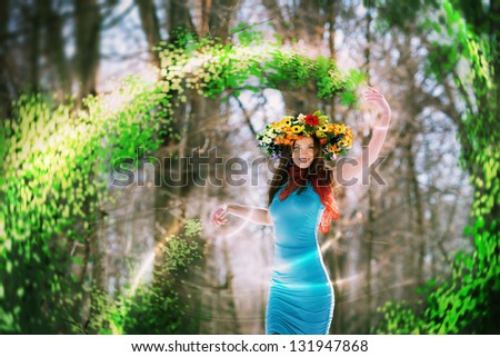 Beautiful God of spring woman with wreath making spring herself in winter forest