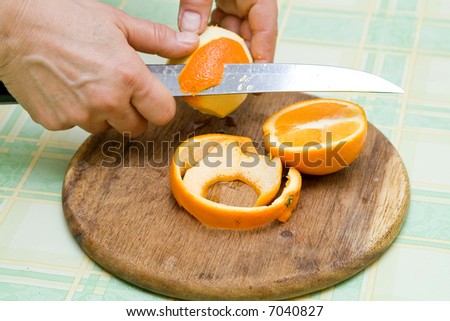woman slicing fruit on kitchen table making fruit salad