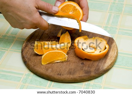 woman slicing fruit on kitchen table making fruit salad