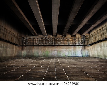 Huge stone and concrete space with tiled floor and ceiling of concrete beams.