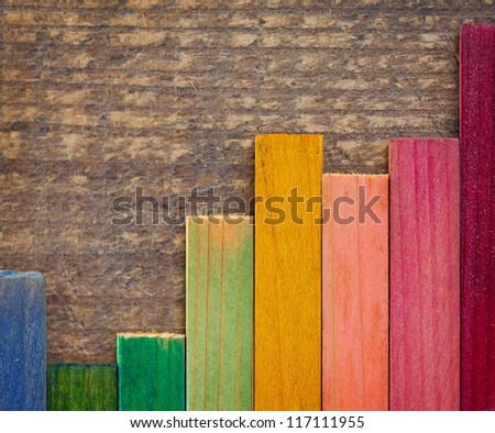 Colorful wood stain color test samples, on rough wood. arranged like a bar graph.