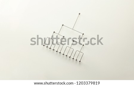 Hierarchy, command chain, company / organization structure or layer and grouping concept image. Top down structure made from gold wires and silver nails and wire on white. Shallow depth of field.