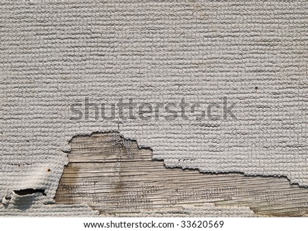 Grungy wall paper texture. Torn and aged white wallpaper on wood.
