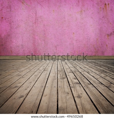 Pink grungy room with worn wooden flooring. Focus on the foreground.