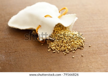 gold nuggets spilling out from a small pouch.