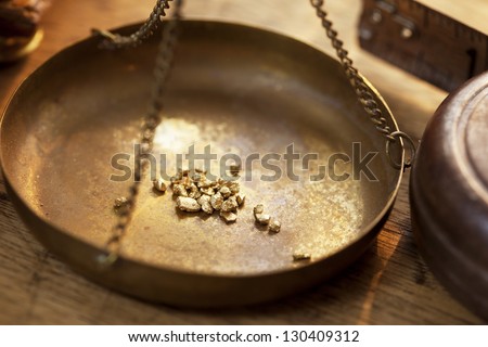 Weighing A Gold Nugget On A Old Brass Scale Dish For Trade Or Exchange.