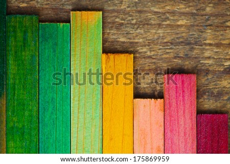 Colorful wood stain color test samples on rough wood. arranged like a bar graph.