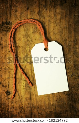 A white blank paper tag on a old wooden desk
