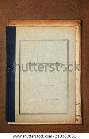 Blank cover of an old grungy note book on old wooden desk.