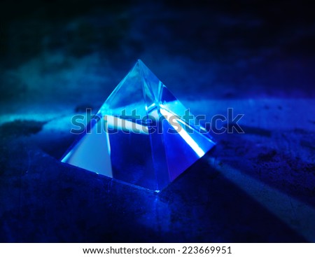 Glass prism with intensive light coming through. refractions of light in a glass prism. Focus is front edge.
