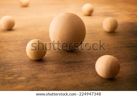 Wooden spheres on a old grungy surface, representing a planetary or atomic particle formation.