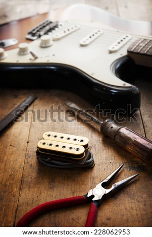 Electric guitar repair. Electric guitar and double coil pickup and tools.