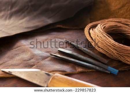 Leather craft. leather crafting tools and thread on a work table.