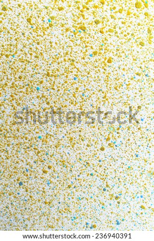 Fine gold paint splatter on white paper, High magnification macro.