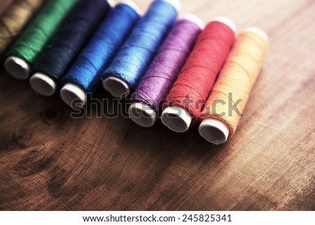 Colored sewing threads on a old work table with impressional feel.