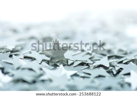 One standing star. One standing silver star among many underlying stars. Intentionally shot in high key and shallow depth of field.