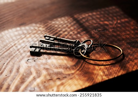 Vintage keys on an grungy old desk with window light shadow. Shallow depth of focus.