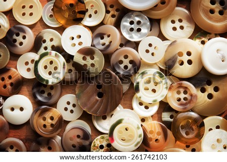 Frame full of clothing buttons. Buttons on a sewing or work table.