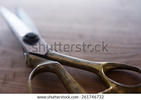 Vintage scissors on a wooden work table. Extremely shallow depth of field for impression-like feel.