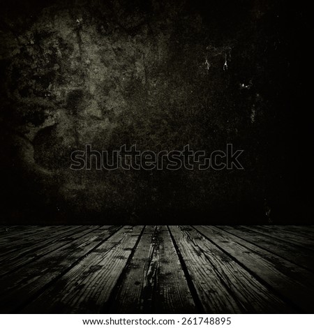 Dark room with stone or masonry wall and grungy old \
wooden floor.