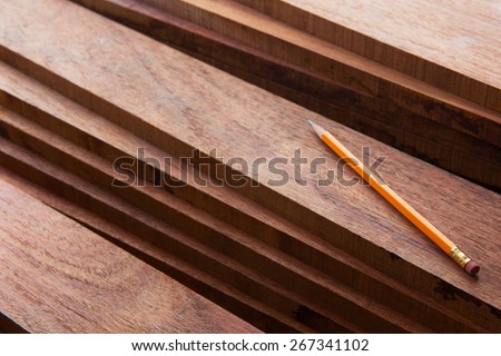 Hard wood lumber stacked with pencil on top. Wood working or interior carpentry.