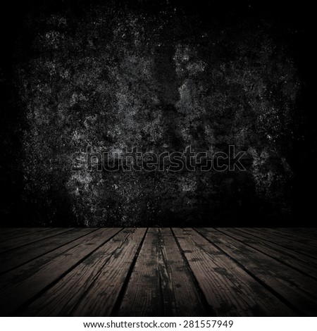 Dark room with stone wall and grungy old wooden floor.