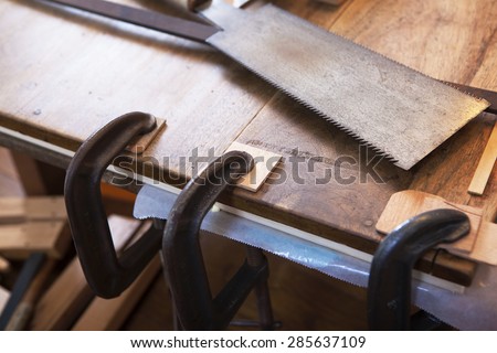 Wood working. Saw, clamps in use and wood on a work bench