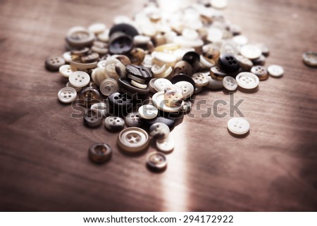 Buttons on a old work table with ray of window light. Shallow depth of field. Intentionally shot in retro tone.