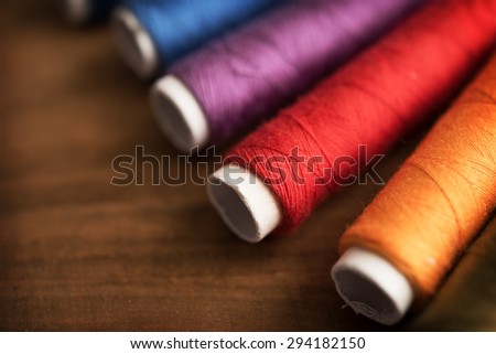 Colored sewing threads on a old work table with impressional feel., Extremely shallow depth of focus for dreamy feel.