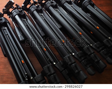 Many camera tripods ready for filming or photo session. Photography or filming equipment.