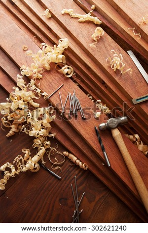 Woodworking, or home renovation. Fine quality hardwood lumber, and wood shavings, nail and hammer on lumber.