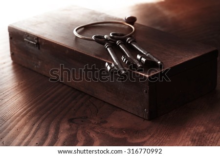 Old keys on a old wooden box. Shallow depth of field. Low key.