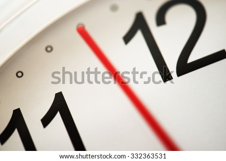Timing or moment. Waiting for the right timing. Few minutes or seconds to the hour. Focus on clock face letter (needle has blur/ movement).  Extremely shallow depth of focus. Impression shot.