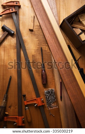 Tools and material on a wood working work bench. Intentionally shot with by the window lighting and low key shadows.