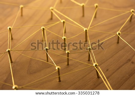 Linking entities. Network, networking, social media, internet communication abstract. Web of gold wires on rustic wood.
