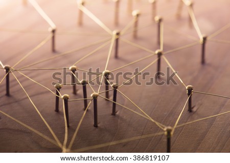Linking entities. Network, networking, social media, connectivity, internet communication abstract. Web of thin gold wires on rustic wood.