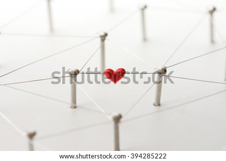 Linking entities. Network, networking, social media, internet communication abstract. Online love or matching. Web of silver wires isolated on natural white, with one connection having a red heart.