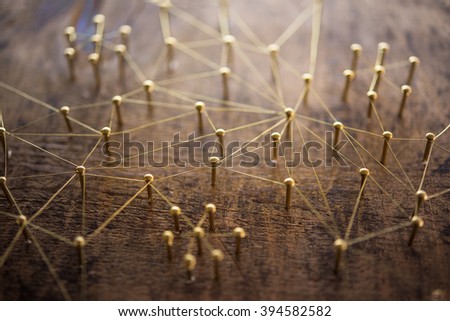 Linking entities. Network, networking, social media, internet communication abstract. Many small network connected to a larger network. Web of gold wires on rustic wood.