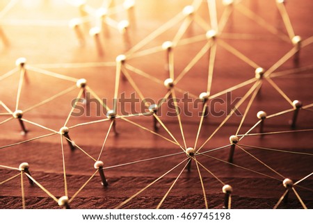 Linking entities. Network, networking, social media, internet communication abstract. Web of gold wires on rustic wood. Shallow depth of field. Intentionally shot in surreal tone.