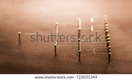 Hierarchy, command chain, company organization chart, structure or layer and grouping concept image. Top down structure made from gold wires and nails on rustic wooden surface. Side view. Shallow DOF.