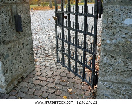 the last way, entrance to cemetery ground, opened iron door and cobble stone pavement