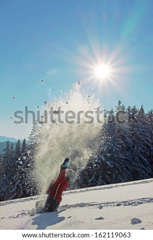 little boy throwing snow in wintry landscape