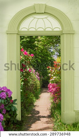 view through arched door, colorful blooming rhododendrons