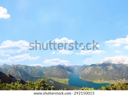 mountainous austrian landscape and empty blue sky background with clouds