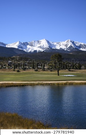 Golf course by snow covered mountains